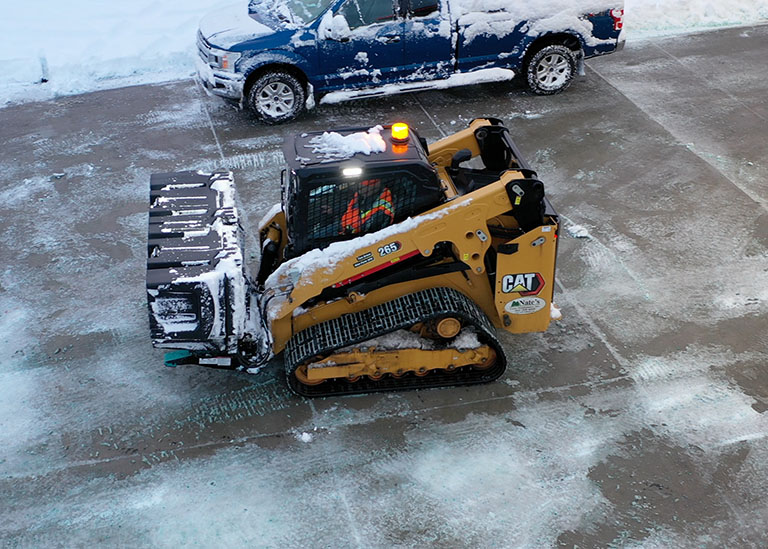 Nate's Snow skid steer driver salting parking lot with SiteTote